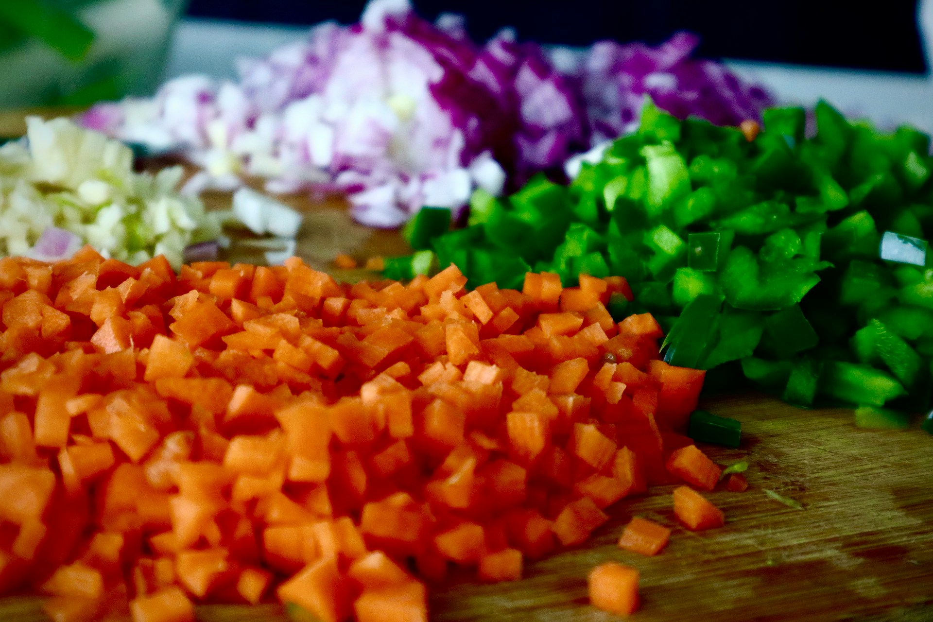 Neatly diced colorful vegetables on a cutting board