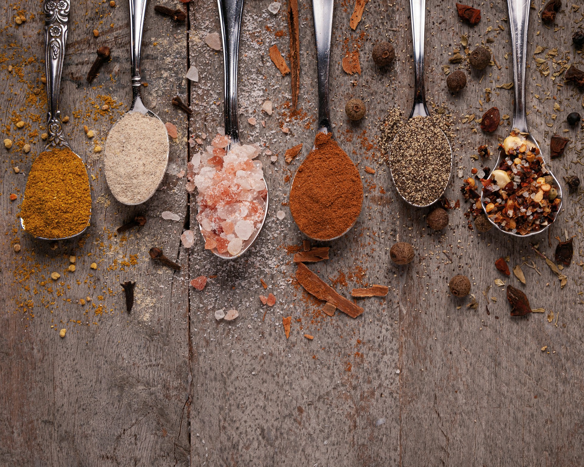 Colorful spices in glass jars arranged on a shelf